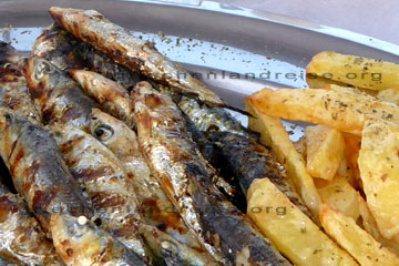 Ancovys auf einem Teller in einem Restaurant beim Griechenland Urlaub auf der Insel Corfu, mit French Fries.