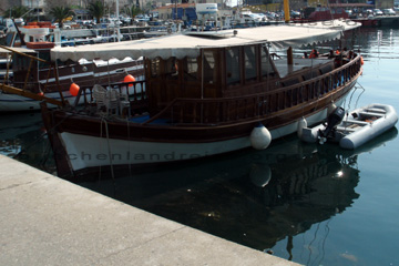 Hausboot in einem Hafen beim Griechenland Urlaub. Da hat man noch ein Schlauchboot mit Außenborder an Steuerbord angebunden, mit dem man kleinere Erledigungen macht.