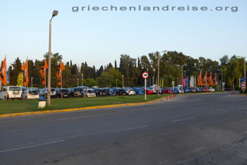 Der Mietwagen-Parkplatz bei unserem Griechenland Urlaub auf der griechischen Insel Korfu direkt am Flugafen, die Fahnen der Mietwagen Anbieter wehen im Wind.