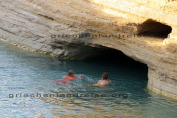 Touristen die eine Unterwasserhöhle beim Griechenland Urlaub auf der griechischen Insel Korfu beim Schwimmen erkunden und geradewegs auf den Höhleneingang zu schwimmen, einfach phantastisch wie klar das Wasser hier an der Küste vom ionischen Meer ist.