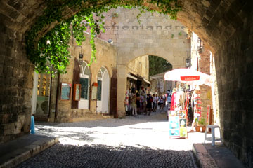 Das ist der Durchgang am Thalassini Stadttor in die Altstadt von Rhodos. Hier Touristen beim schlendern vorbei an den Geschäften wo man sich Souvenirs kaufen kann.