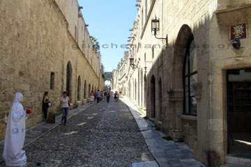 Blick in die Ritterstraße der Altstadt von Rhodos. Links im Bild die weiße Pantomime Künstlerin.
