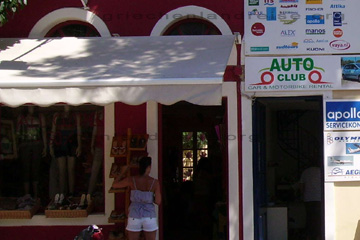 Eine Touristin in kurzen weißen Hosen und Trägershirt betrachtet sich ein Schaufenster einer der Boutiquen in dem Ferienort Pythagorio im Süden der griechischen Insel Samos.