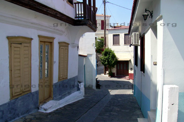 Gässchen in dem Vourliotes Bergdorf auf der griechischen Insel Samos. Blau-weiß getünchte Hausfassaden und Balkonerker, die Attika mit edlem Holz verkleidet.
